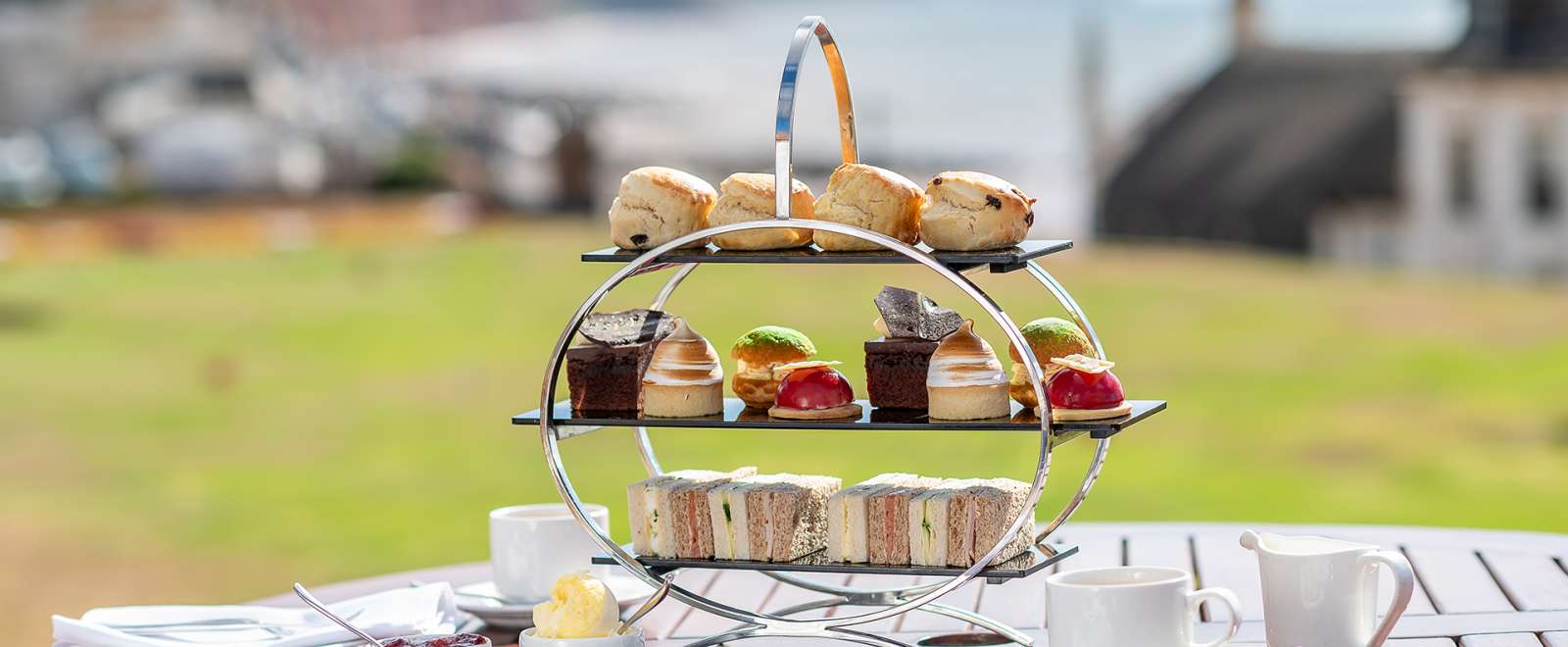 Afternoon Tea on a wooden table with Jurassic Coast in the background