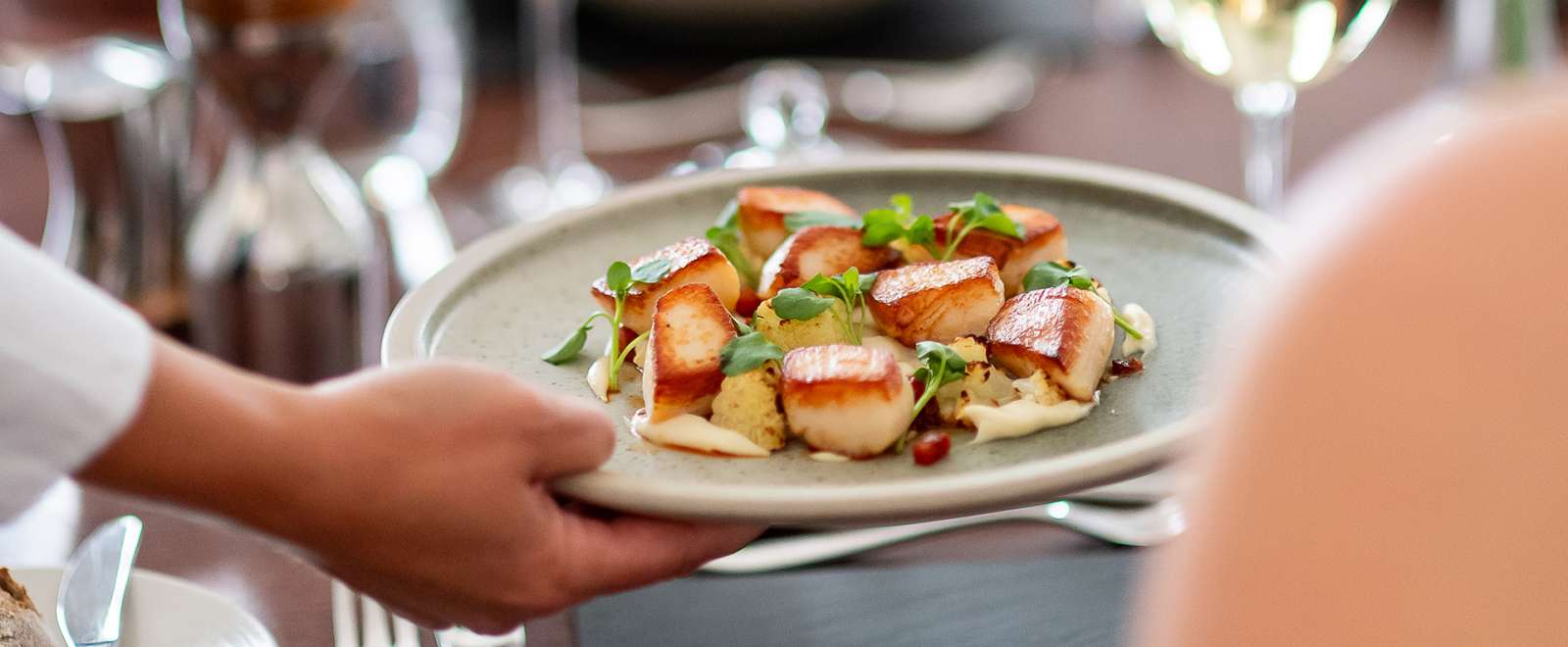 Hand serving Scallop dish in The White Room