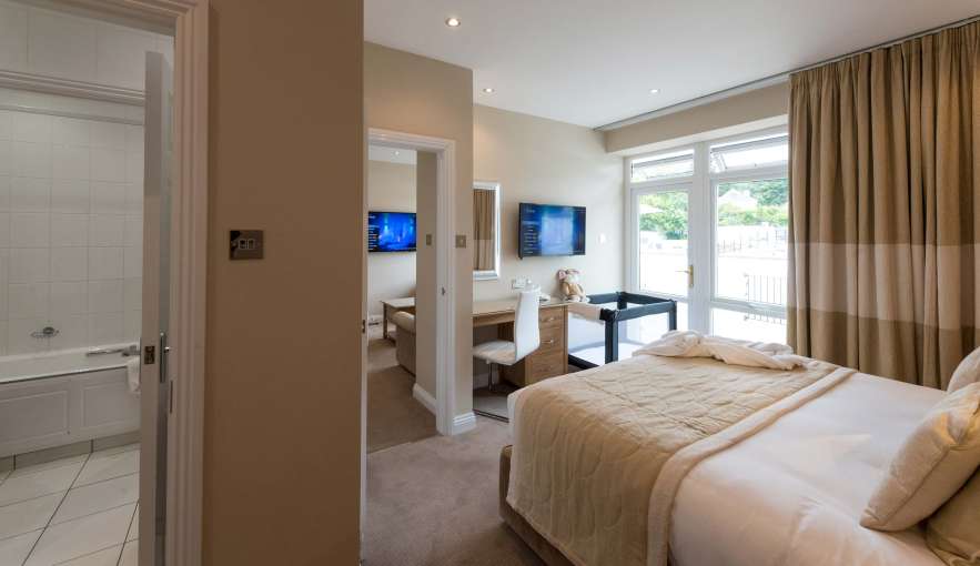 Victoria Hotel Poolside Suite Accommodation Bedroom with Cot and Door to Bathroom