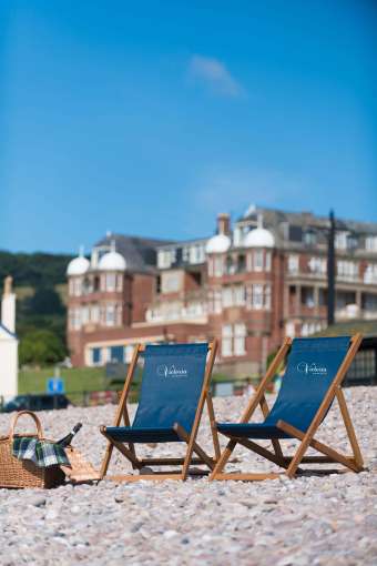 Victoria Hotel Deck Chairs on Beach with Hotel in Background