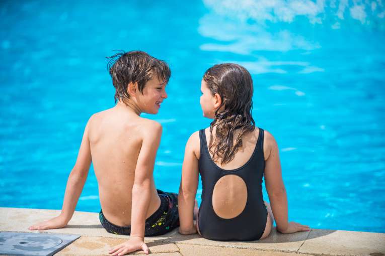 Children Looking at Each Other on Edge of Pool