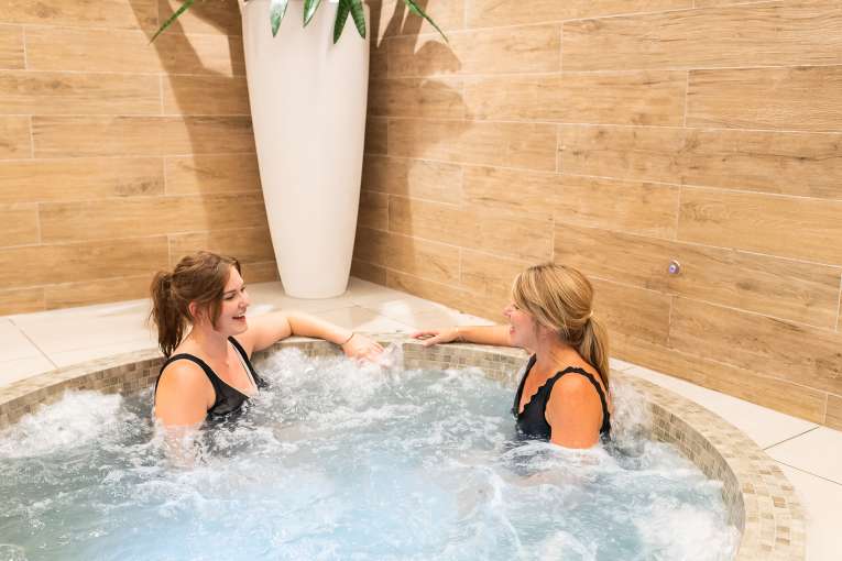 Two women sat in the Jacuzzi talking