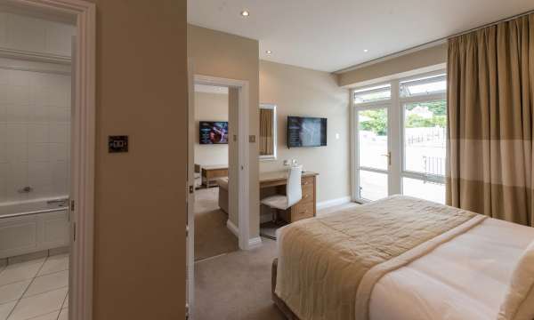 Victoria Hotel Poolside Suite Accommodation Bedroom with Desk and Door to Bathroom