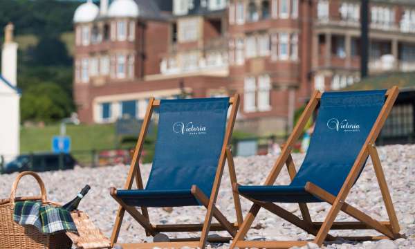 Victoria Hotel Deck Chairs on Beach with Hotel in Background
