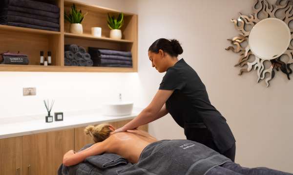 Spa therapist giving a back massage