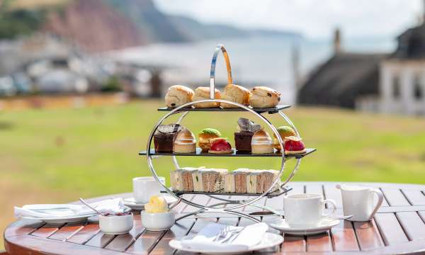 Afternoon Tea on a wooden table with Jurassic Coast in the background