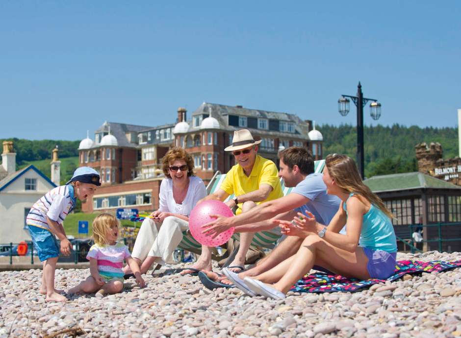 Victoria Hotel Family Sitting on Beach with Hotel in Background