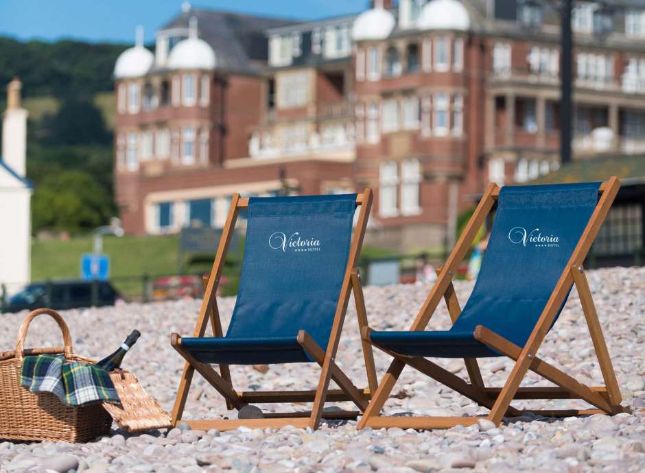 Victoria Hotel Deck Chairs on Beach with Hotel in Background