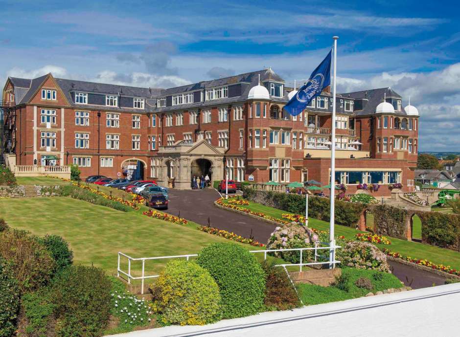 Victoria Hotel External View with Flag and Gardens