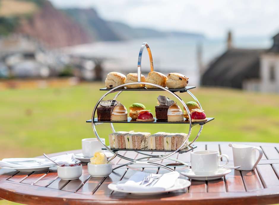 Afternoon Tea on a wooden table with Jurassic Coast in the background
